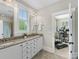 Bathroom with double vanity, granite countertop, tile floor, and view into exercise room at 601 Dorothy Dr, Charlotte, NC 28203