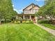 Charming two-story home with a inviting front porch, lush landscaping, and a well-manicured lawn at 601 Dorothy Dr, Charlotte, NC 28203