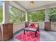Cozy porch with comfortable red seating, decorative rug, brick pillars and white railings at 601 Dorothy Dr, Charlotte, NC 28203
