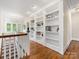 Hallway with hardwood floors and built-in bookshelves, providing ample storage and display space at 601 Dorothy Dr, Charlotte, NC 28203