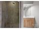 Modern bathroom boasts a glass shower, and wood vanity with white countertop at 625 N Alexander St, Charlotte, NC 28202