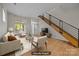 Bright, staged living room with hardwood floors, modern staircase, and large windows at 625 N Alexander St, Charlotte, NC 28202
