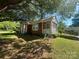 Quaint brick home featuring a screened-in porch and lush greenery in a peaceful setting at 6585 White St, Kershaw, SC 29067