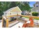 Backyard deck featuring railings and furniture, with a detached two-car garage and lush greenery beyond at 7814 Knox Ridge Rd, Huntersville, NC 28078