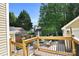 Backyard deck overlooks patio with fire pit and furniture, string lights for outdoor enjoyment, beautiful landscaping at 7814 Knox Ridge Rd, Huntersville, NC 28078