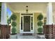 Inviting front porch featuring manicured landscaping, decorative wreath, stylish front door, and custom hardware at 7814 Knox Ridge Rd, Huntersville, NC 28078