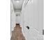 Hallway with wood flooring, multiple white doors and a bathroom with shower curtain in view at 7814 Knox Ridge Rd, Huntersville, NC 28078
