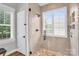 Walk-in shower featuring tan tiling, a large window and an adjacent stool at 7814 Knox Ridge Rd, Huntersville, NC 28078