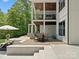 A multi-level back patio features a dining table, chairs, and an upper balcony showcasing the outdoor living space at 8044 Edgewater Dr # 100, Norwood, NC 28128