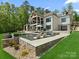 The backyard boasts a stunning pool and lush landscaping, complementing the home's architectural beauty and outdoor living at 8044 Edgewater Dr # 100, Norwood, NC 28128