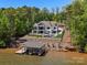 Stunning lakefront home featuring a private pool, dock, lush landscaping, and an expansive backyard perfect for entertaining at 8044 Edgewater Dr # 100, Norwood, NC 28128