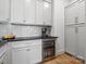 This kitchenette features white cabinets, black countertops, and a built-in beverage refrigerator at 8044 Edgewater Dr # 100, Norwood, NC 28128
