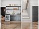 Wet bar with custom cabinets, display shelving, stainless steel mini-fridge, and staircase at 8044 Edgewater Dr # 100, Norwood, NC 28128