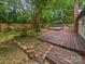 Expansive backyard featuring multi-tiered wooden deck, mature trees, and a private, serene setting at 8600 Eaglewind Dr, Charlotte, NC 28212