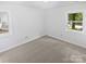 Bright bedroom featuring neutral carpeting, fresh white paint, and natural light from two windows at 8600 Eaglewind Dr, Charlotte, NC 28212