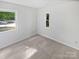 Clean bedroom showing neutral carpeting, white painted walls, and natural light through two windows at 8600 Eaglewind Dr, Charlotte, NC 28212