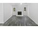Bright living room features a white fireplace, neutral walls, stylish gray tile floor, and natural light from windows at 8600 Eaglewind Dr, Charlotte, NC 28212