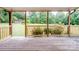 Covered back porch overlooking mature trees and a storage shed at 895 Furnace Rd, Iron Station, NC 28080