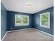 Bright blue bedroom featuring two windows offering verdant outdoor views at 895 Furnace Rd, Iron Station, NC 28080