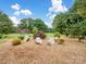 Landscaped front yard featuring decorative rocks, mulch, and mature trees at 895 Furnace Rd, Iron Station, NC 28080