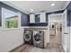 Convenient laundry room with modern washer and dryer, storage cabinets, and a bright window at 895 Furnace Rd, Iron Station, NC 28080