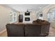 Cozy living room featuring a brick fireplace, ceiling fan, and new luxury vinyl flooring at 895 Furnace Rd, Iron Station, NC 28080