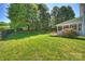 Spacious backyard featuring a well-manicured lawn, mature trees, and a charming screened-in porch at 9209 Cameron Wood Dr, Charlotte, NC 28210