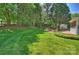 Expansive backyard with lush green grass, mature trees, and an inviting patio area with outdoor seating at 9209 Cameron Wood Dr, Charlotte, NC 28210