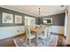 Formal dining room features a wooden table, neutral chairs, and a stylish chandelier, perfect for gatherings at 9209 Cameron Wood Dr, Charlotte, NC 28210