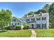 Charming two-story home with a well-manicured lawn, black shutters, and a classic American flag at 9209 Cameron Wood Dr, Charlotte, NC 28210