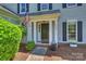 Close-up view of the home's entry showcasing its well-kept landscaping, flowers, and American flag at 9209 Cameron Wood Dr, Charlotte, NC 28210