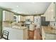 A well lit kitchen featuring white cabinetry, stainless steel appliances, granite countertops, and hardwood floors at 9209 Cameron Wood Dr, Charlotte, NC 28210