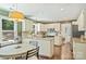 A well lit eat-in kitchen featuring white cabinetry, stainless steel appliances, granite countertops, and hardwood floors at 9209 Cameron Wood Dr, Charlotte, NC 28210