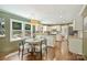Bright eat-in kitchen featuring white cabinetry, stainless steel appliances, granite countertops, and hardwood floors at 9209 Cameron Wood Dr, Charlotte, NC 28210