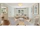 Bright living room with four armchairs, hardwood floors, and double doors leading to the outdoor deck at 9209 Cameron Wood Dr, Charlotte, NC 28210