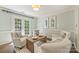 Bright and airy living space with white armchairs, hardwood floors, and patio access through glass doors at 9209 Cameron Wood Dr, Charlotte, NC 28210