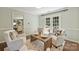 Comfortable living room featuring white armchairs, hardwood floors, and a view into the adjacent kitchen at 9209 Cameron Wood Dr, Charlotte, NC 28210