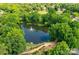 Aerial view of serene pond with a fountain and walking path, surrounded by lush greenery at 9209 Cameron Wood Dr, Charlotte, NC 28210