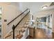 Elegant staircase with dark railings, carpeted steps, and a clear view into the dining area at 9209 Cameron Wood Dr, Charlotte, NC 28210