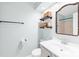 Well-lit bathroom with a single sink vanity and storage shelves at 9214 N Vicksburg Park Ct, Charlotte, NC 28210