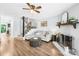 Cozy living room with fireplace, ceiling fan, modern furnishings, and wood flooring at 9214 N Vicksburg Park Ct, Charlotte, NC 28210