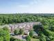 Aerial view of apartments surrounded by trees, with a distant city skyline at 1000 E Woodlawn Rd # 402, Charlotte, NC 28209