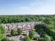 Aerial view of apartments surrounded by trees, with a distant city skyline at 1000 E Woodlawn Rd # 402, Charlotte, NC 28209
