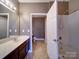 Bathroom featuring vanity and shower with brown walls and light tile flooring at 1000 E Woodlawn Rd # 402, Charlotte, NC 28209