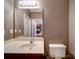 Bathroom featuring vanity, large mirror, and toilet with a tan wall at 1000 E Woodlawn Rd # 402, Charlotte, NC 28209