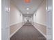Long carpeted hallway with neutral walls and ceiling lights offers quiet passage to residences at 1000 E Woodlawn Rd # 402, Charlotte, NC 28209