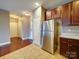 Well-lit kitchen boasts stainless steel refrigerator, ceramic tile flooring, and sleek, wood cabinets at 1000 E Woodlawn Rd # 402, Charlotte, NC 28209