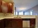 Kitchen features stainless dishwasher, granite countertops, and wood cabinets overlooking an open living area at 1000 E Woodlawn Rd # 402, Charlotte, NC 28209
