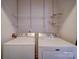 Close up view of laundry room with white washer and dryer and wire rack shelving at 1000 E Woodlawn Rd # 402, Charlotte, NC 28209