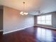 Light-filled living room with hardwood floors, ceiling fan, and open layout to kitchen area at 1000 E Woodlawn Rd # 402, Charlotte, NC 28209